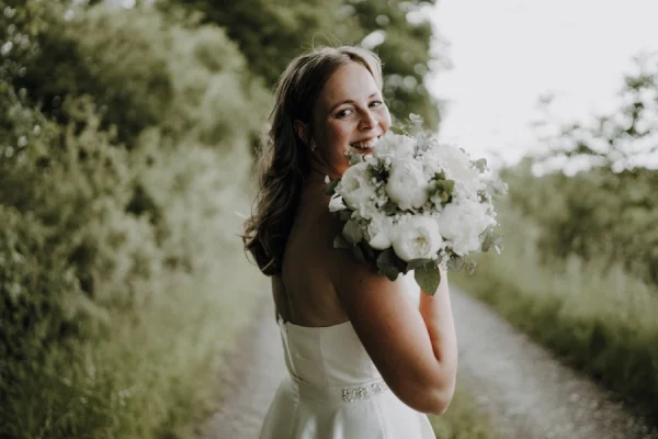 Portrait der Braut mit Blumenstrauß in der Natur